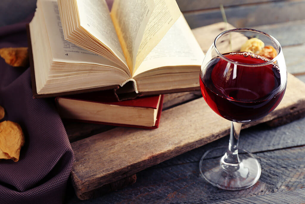 Livros sobre vinho: Taça de vinho ao lado de vinho.
